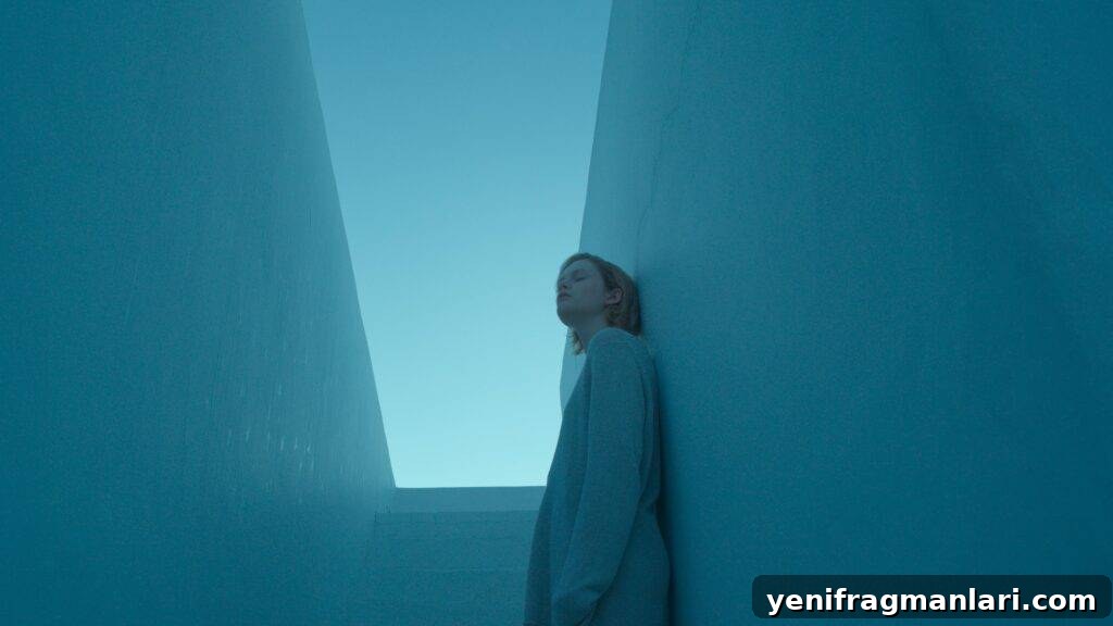 Emma Baird as Lola in the film Satisfaction, covered in blue with a sliver of light