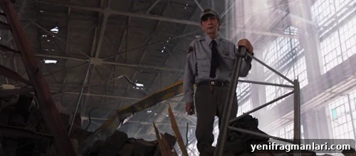 10 Iconic Harry Dean Stanton Performances 2 Security Officer in cap and tie stands in well-lit warehouse.