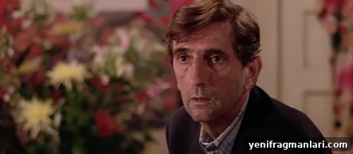 10 Iconic Harry Dean Stanton Performances 8 A father with short brown hair and worn features looks nervously towards the camera, flowers over his right shoulder.