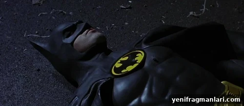 10 Iconic Batman Moments That Shaped the Dark Knight 4 Michael Keaton lies motionless on the dark pavement floor whilst wearing the Batsuit from 'Batman' (1989).