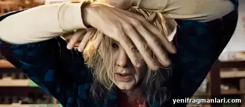 Nicolas Cage in heavy makeup and prosthetics, with his hands crossing his face, in 2024 feature horror film 'Longlegs'.