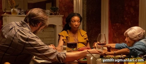 The Front Room (2024) Review: A Haunting Small-Town Thriller 2 Brandy Norwood holding hands at the table in 2024 horror feature film 'The Front Room'.
