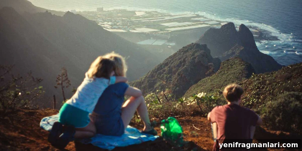 Everytime Review: Grief, Memory, and a Hidden Glimmer 2 Melli hugs her mother, Ella, on a mountainside overlooking the Tenerife coastline, while Lux sits to their right in Everytime.